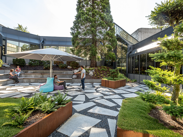 Short break on the PROBAT campus Employees sit on a campus surrounded by the company building and some plants